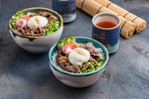 rice and beef bowls with tea concrete background PSUEHUF